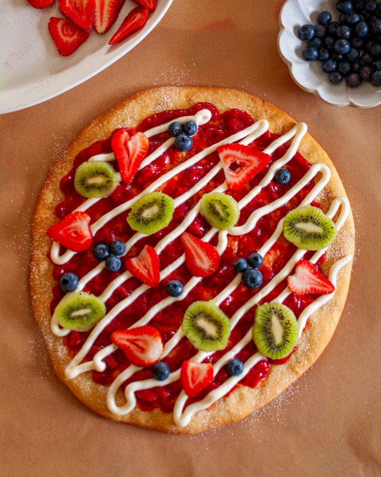 20240417-DSC_0037 Fruit pizza with strawberry sauce, cream cheese frosting, strawberries, blueberries and kiwi slices.