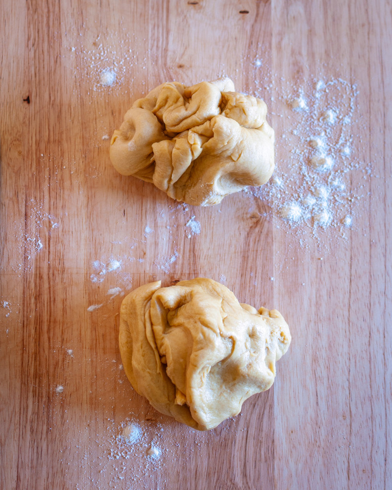 Two sections of dough on a lightly floured pastry board